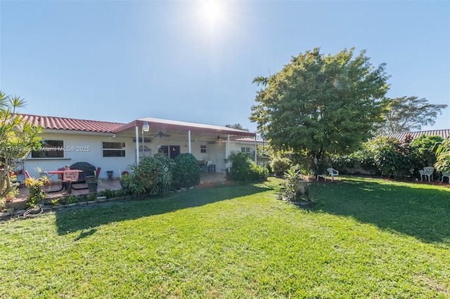 view of yard featuring a ceiling fan and a patio area