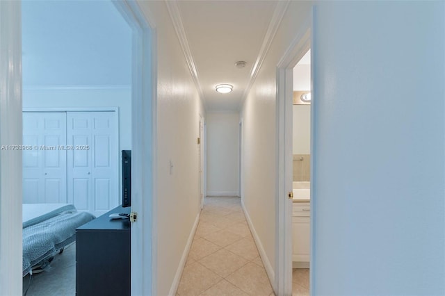 hallway featuring crown molding and light tile patterned flooring