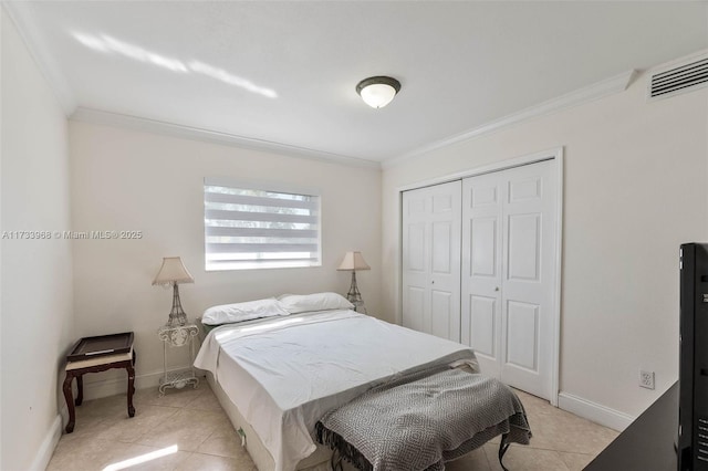 tiled bedroom with ornamental molding and a closet