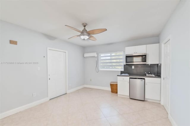 kitchen with decorative backsplash, a ceiling fan, an AC wall unit, stainless steel appliances, and white cabinetry