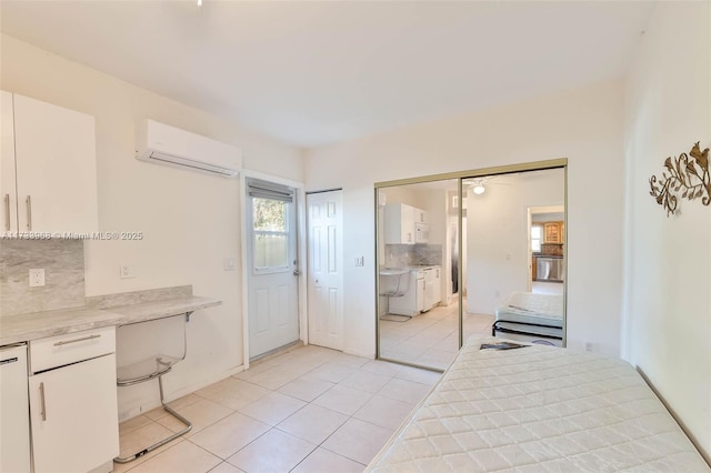 interior space featuring tasteful backsplash, a wall mounted AC, and white cabinets