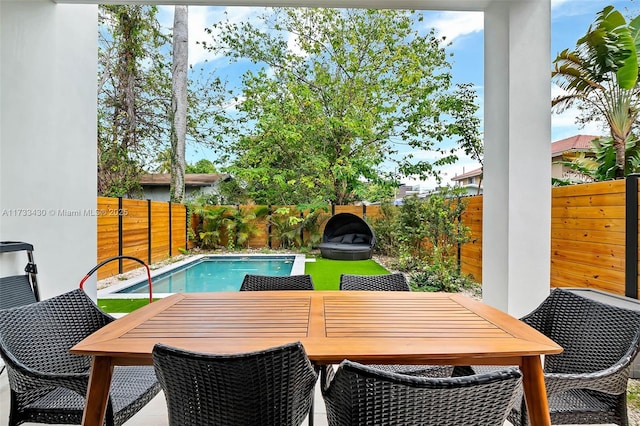 view of pool featuring outdoor dining space, a fenced in pool, and a fenced backyard