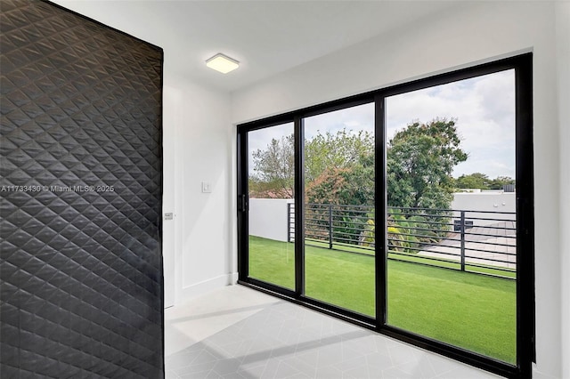 doorway featuring tile patterned floors and baseboards