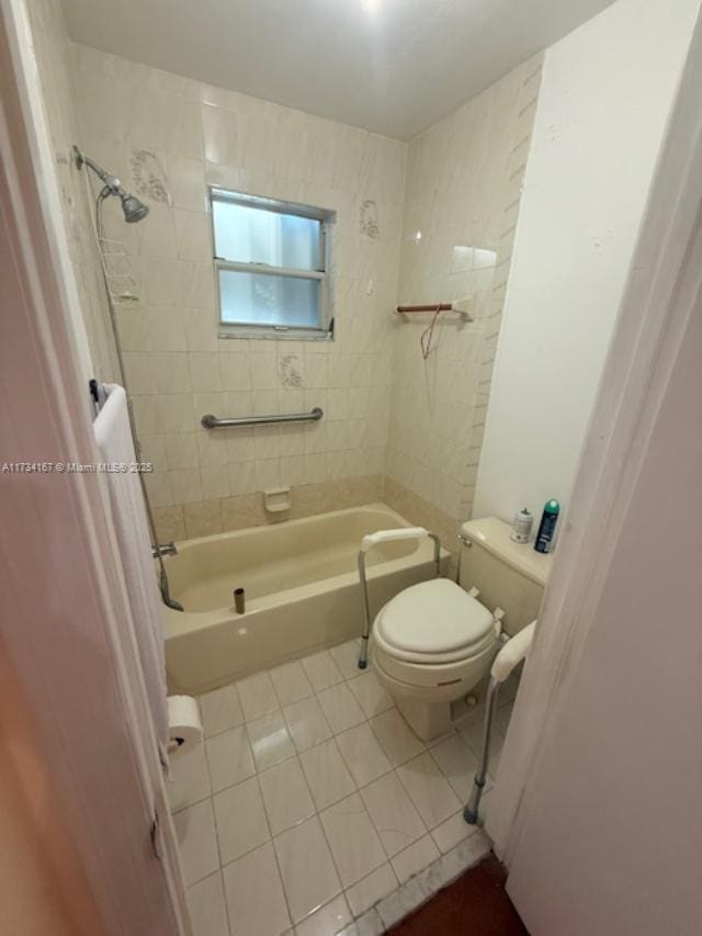 bathroom with toilet, tiled shower / bath combo, and tile patterned flooring