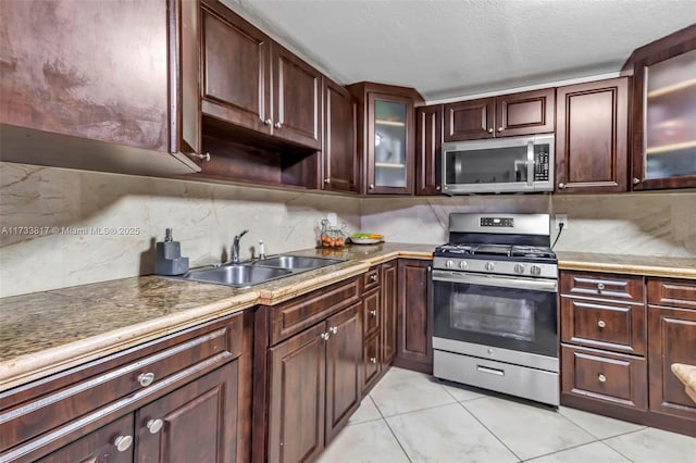 kitchen featuring sink, backsplash, stainless steel appliances, a textured ceiling, and light tile patterned flooring