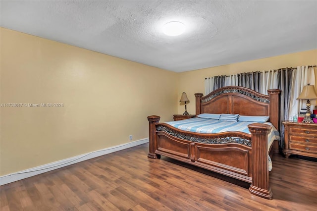 bedroom with dark hardwood / wood-style floors and a textured ceiling