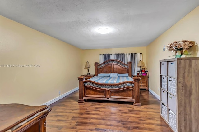 bedroom featuring dark hardwood / wood-style floors and a textured ceiling