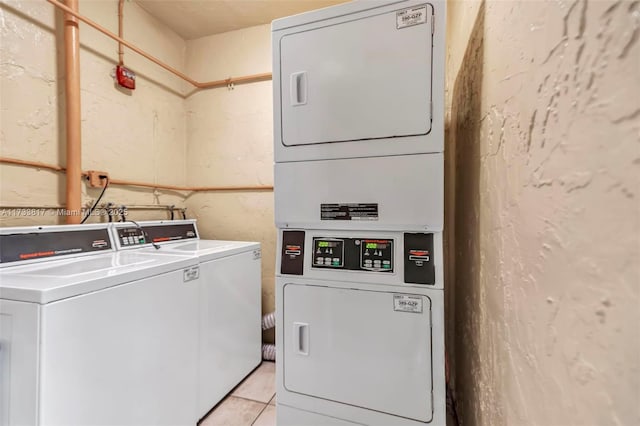 washroom with stacked washer / dryer, light tile patterned floors, and washer and clothes dryer