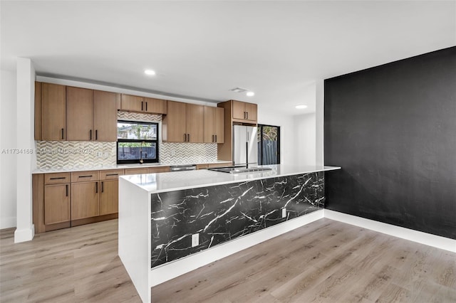 kitchen with sink, light hardwood / wood-style floors, and stainless steel refrigerator