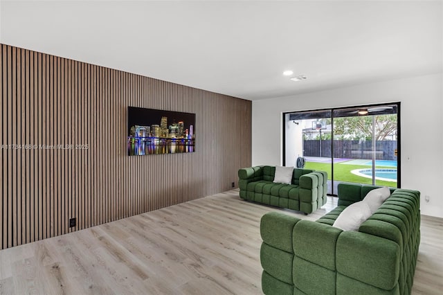 living room featuring light hardwood / wood-style flooring and wood walls