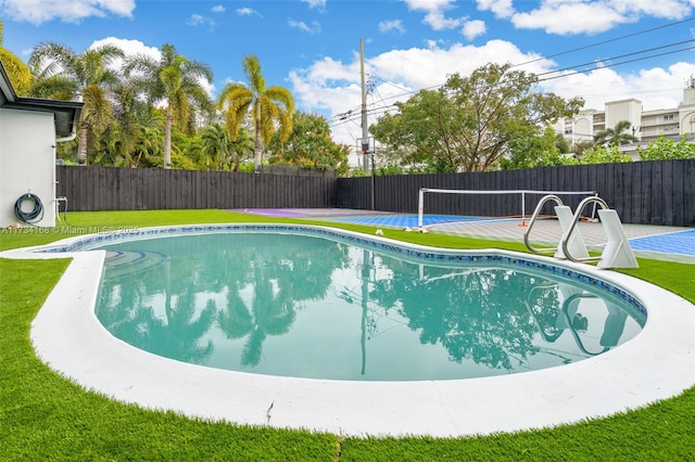 view of swimming pool featuring a yard and tennis court