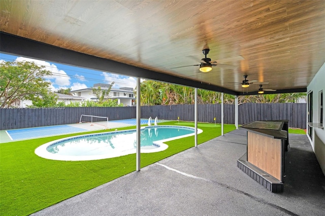 view of swimming pool featuring a yard, a patio area, and ceiling fan