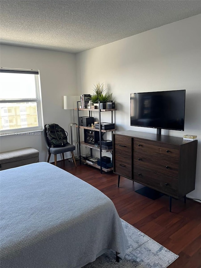 bedroom featuring dark wood-type flooring and a textured ceiling