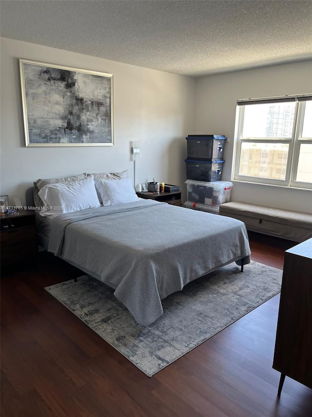 bedroom featuring dark wood-type flooring and a textured ceiling