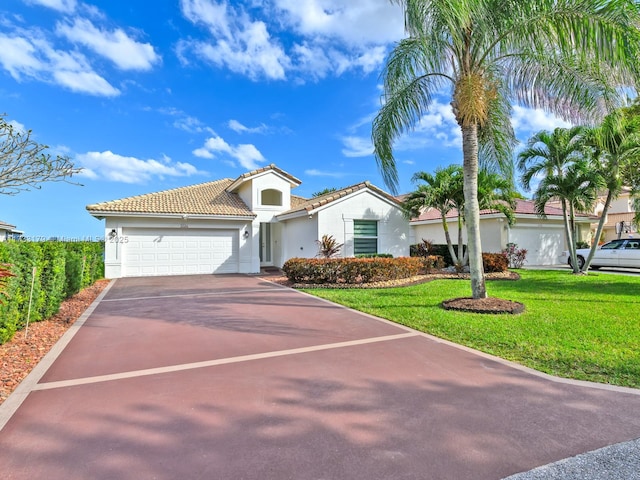 mediterranean / spanish-style house featuring a garage and a front lawn