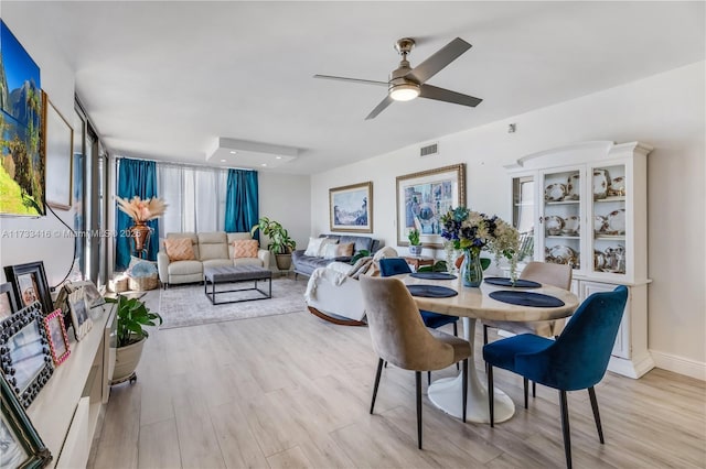 dining space with light hardwood / wood-style flooring and ceiling fan