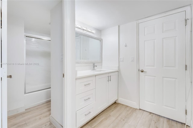 bathroom with vanity, a shower with door, and hardwood / wood-style floors