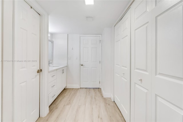 hall featuring sink and light hardwood / wood-style flooring