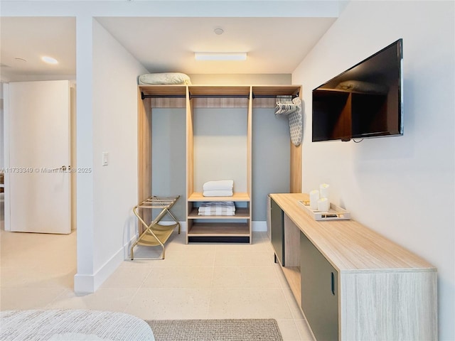 bedroom with light tile patterned floors and baseboards