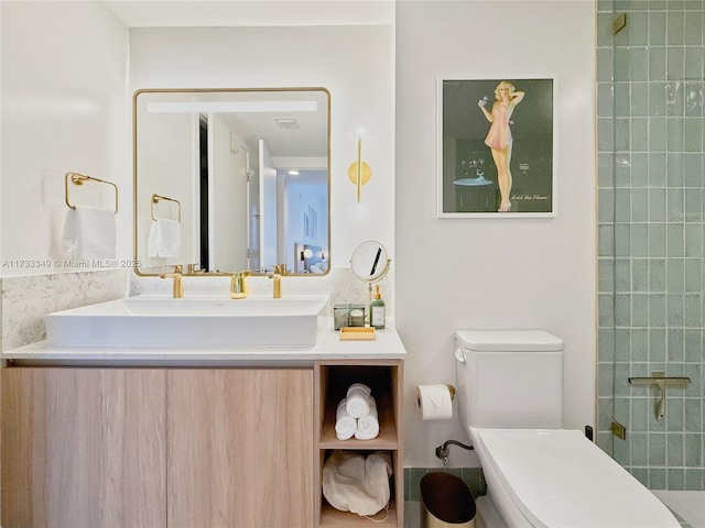 bathroom featuring visible vents, toilet, vanity, and a tile shower