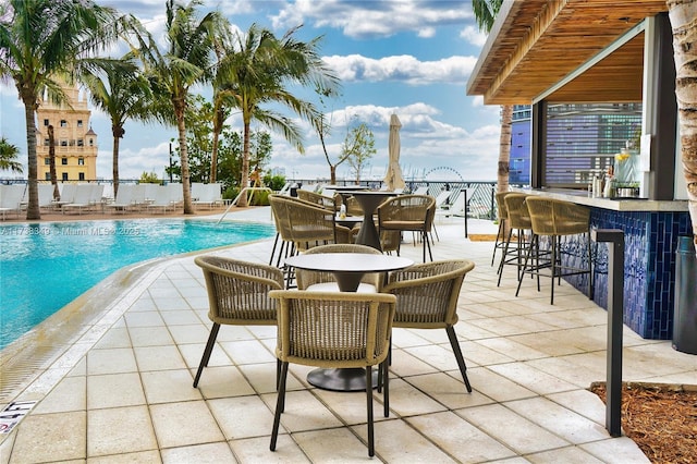 exterior space with outdoor dining area, a community pool, and outdoor dry bar