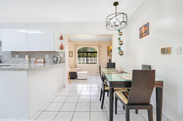 dining area with light tile patterned floors and a chandelier