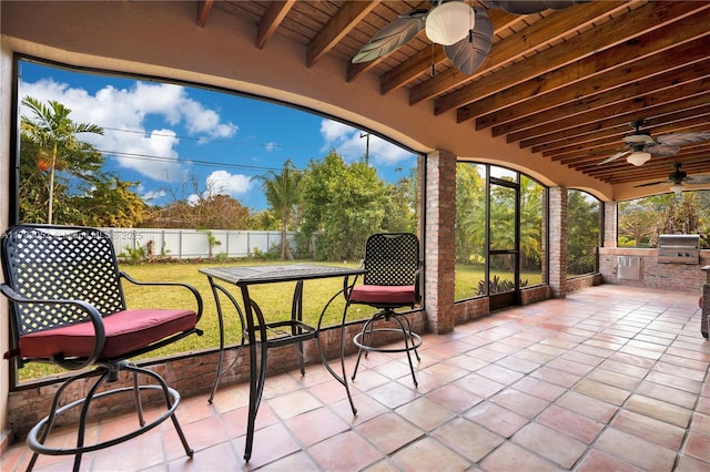 sunroom with beam ceiling, wood ceiling, and ceiling fan