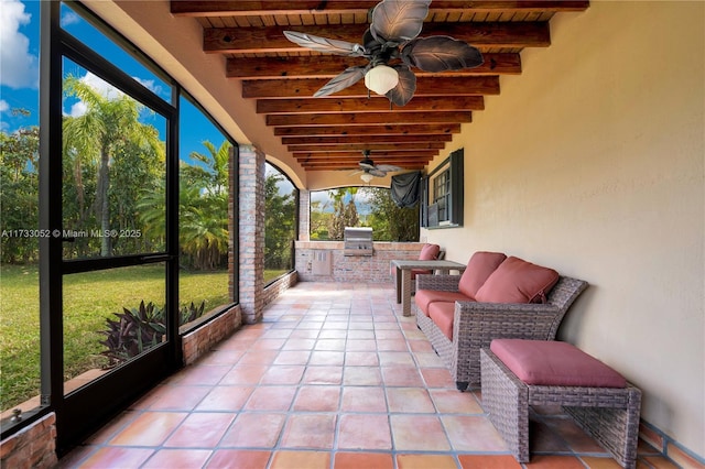 sunroom / solarium featuring beam ceiling, wooden ceiling, and ceiling fan