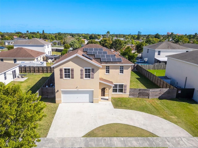 view of front of home featuring a garage, a front yard, and solar panels