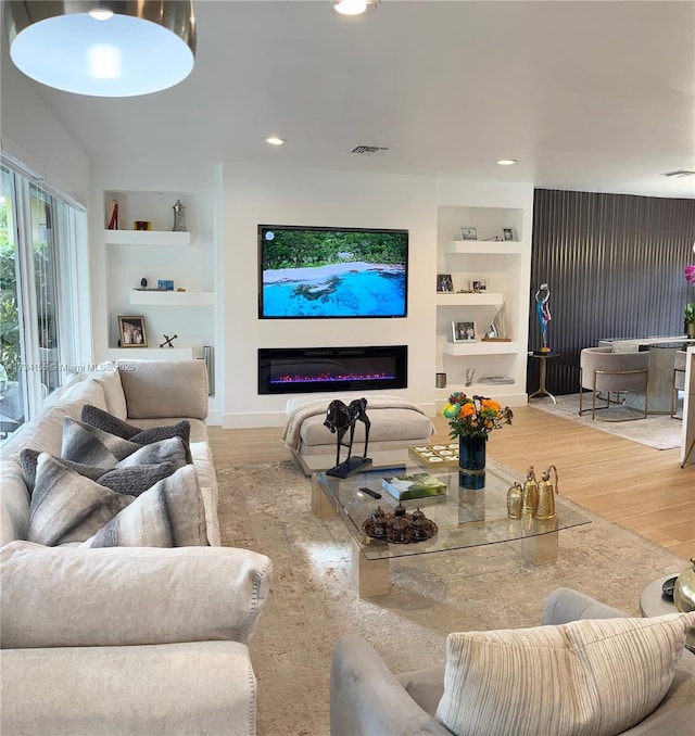 living room with hardwood / wood-style floors and built in shelves