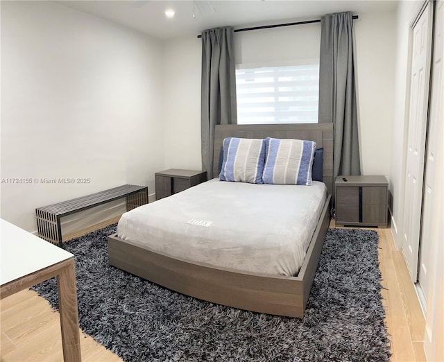 bedroom with light hardwood / wood-style floors and a closet