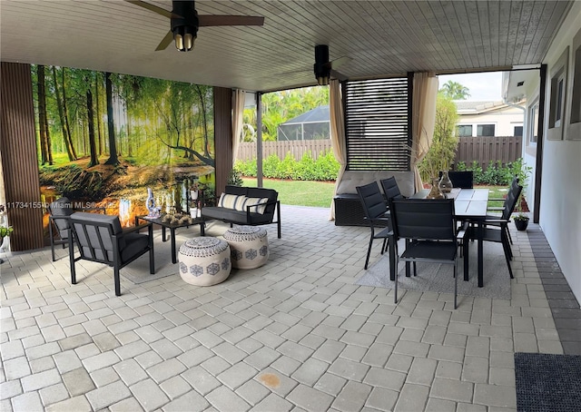 view of patio / terrace featuring ceiling fan and an outdoor living space with a fire pit