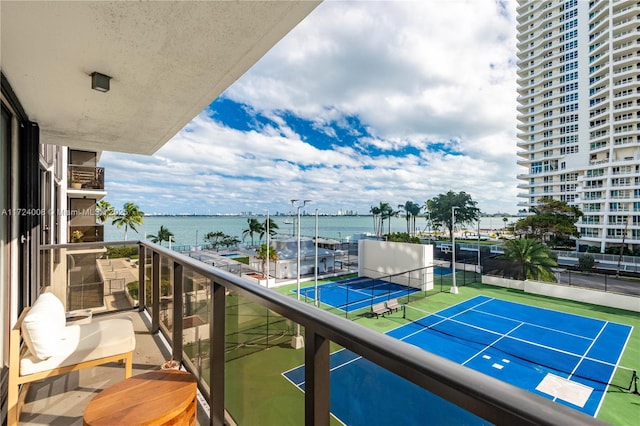 balcony with a water view and tennis court