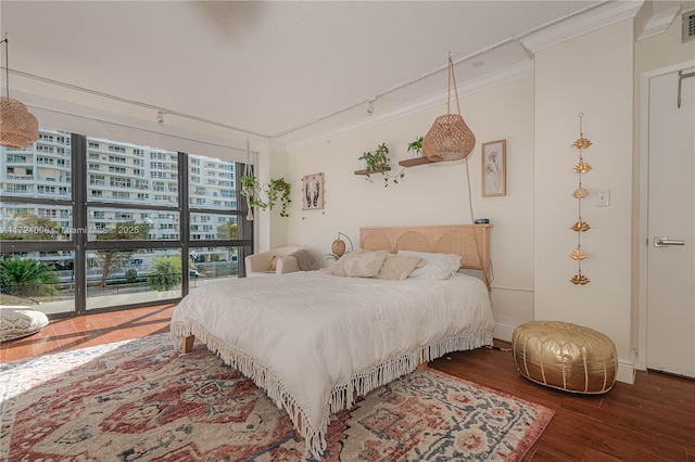 bedroom with crown molding and dark wood-type flooring