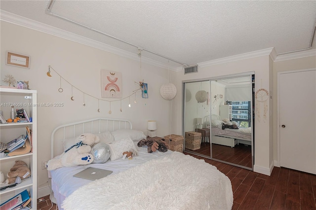 bedroom featuring crown molding, a textured ceiling, and a closet