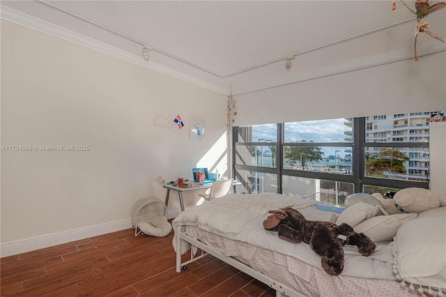 bedroom with ornamental molding and rail lighting