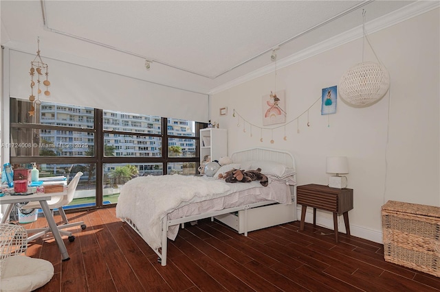 bedroom featuring dark wood-type flooring, a wall of windows, and ornamental molding