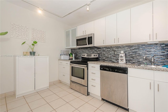 kitchen featuring sink, rail lighting, white cabinetry, stainless steel appliances, and tasteful backsplash