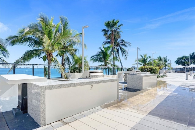 view of patio featuring a water view, area for grilling, grilling area, and sink