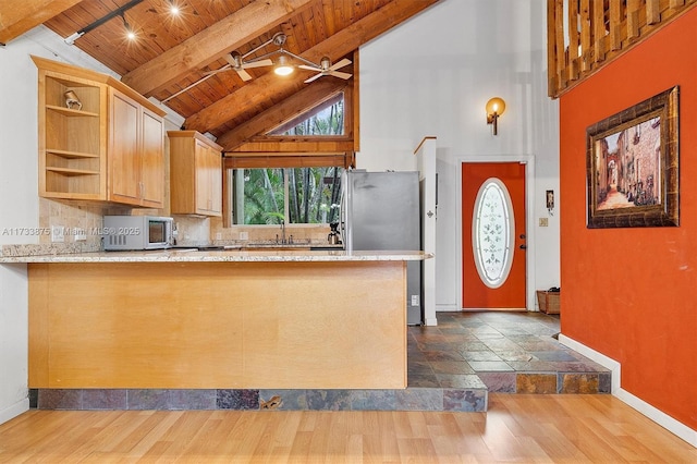 kitchen featuring tasteful backsplash, beamed ceiling, wood ceiling, kitchen peninsula, and light brown cabinets