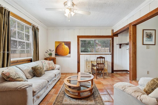 tiled living room featuring ornamental molding, a textured ceiling, and ceiling fan