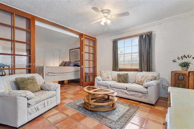 tiled living room featuring crown molding, ceiling fan, and french doors