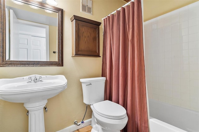 bathroom featuring shower / bath combination with curtain and toilet