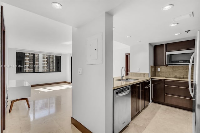 kitchen with dark brown cabinetry, sink, electric panel, stainless steel appliances, and backsplash