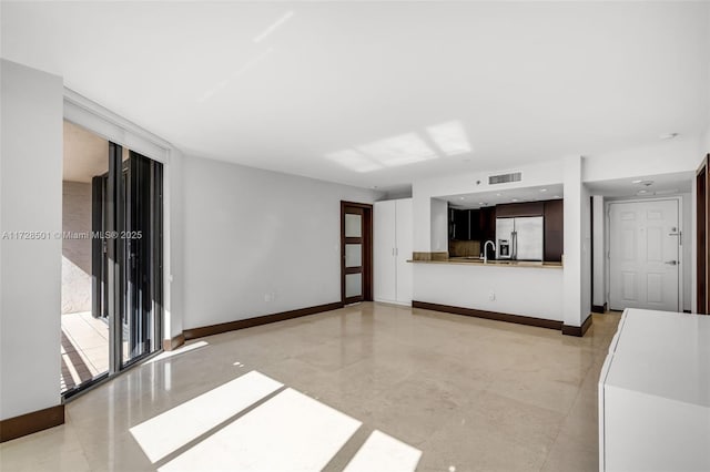 unfurnished living room featuring sink