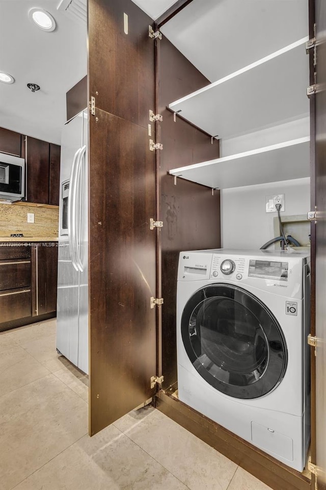 laundry room featuring light tile patterned floors and washer / dryer