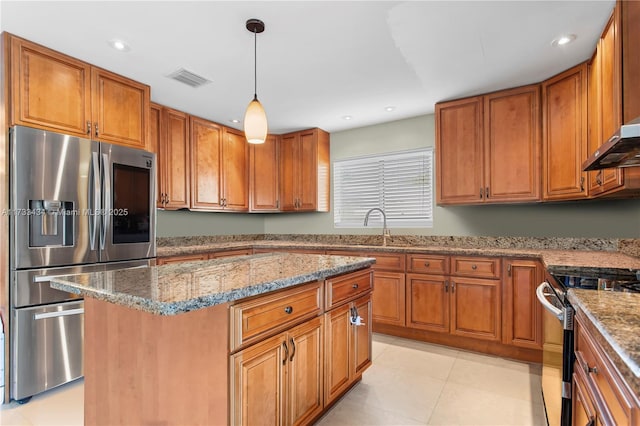 kitchen featuring appliances with stainless steel finishes, pendant lighting, sink, a center island, and light stone counters