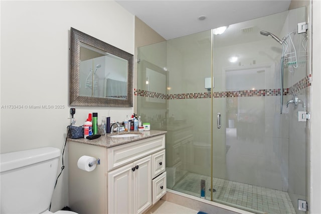 bathroom with vanity, an enclosed shower, and toilet