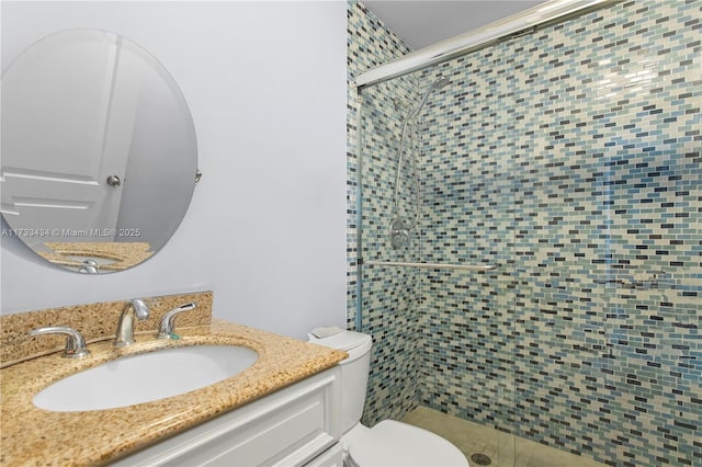 bathroom with vanity, a shower with shower door, and toilet