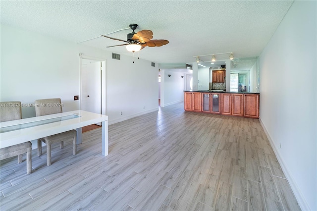 interior space featuring a textured ceiling and light wood-type flooring